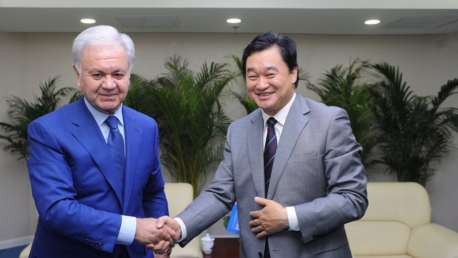 新華網董事長、總裁田舒斌與上海合作組織秘書長阿利莫夫親切握手